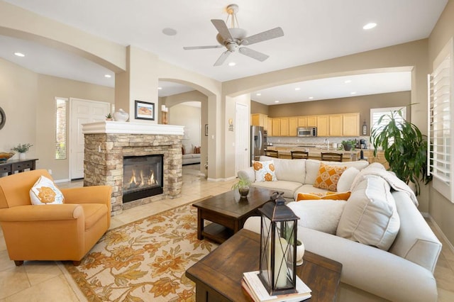 living room with ceiling fan, light tile patterned floors, and a fireplace