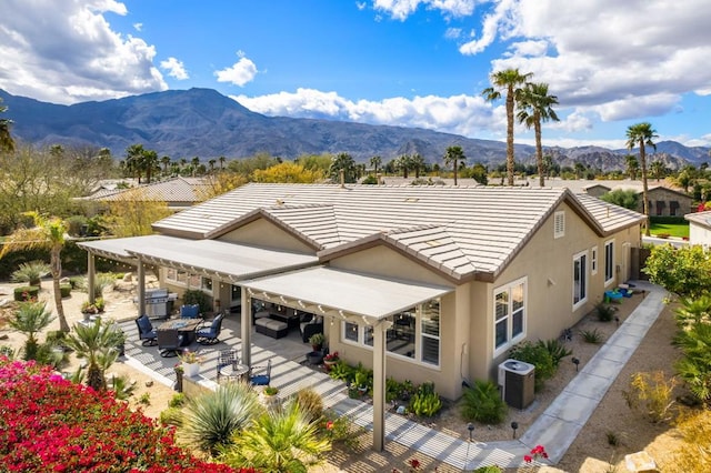 rear view of property featuring a mountain view, central AC, and a patio