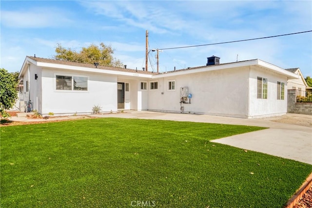 rear view of property with a yard and a patio area