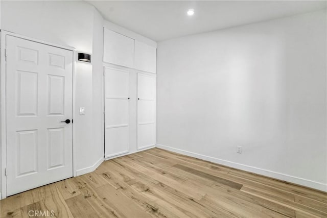 unfurnished bedroom with light hardwood / wood-style floors and a closet