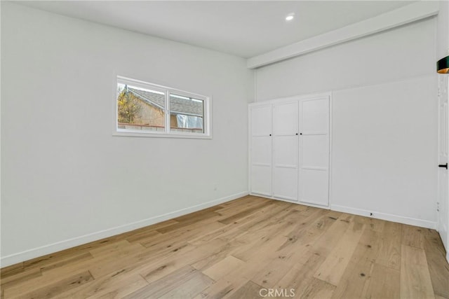 unfurnished bedroom with light hardwood / wood-style floors and a closet