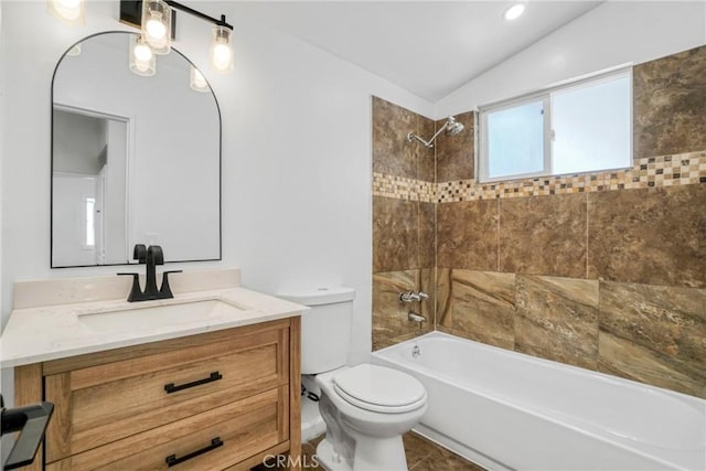 full bathroom with tiled shower / bath, lofted ceiling, toilet, and vanity