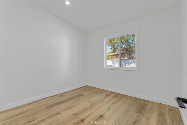 unfurnished room with vaulted ceiling and light hardwood / wood-style floors