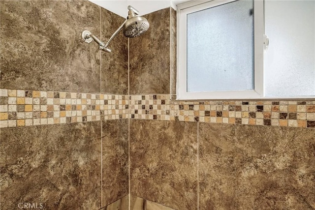 interior details featuring a tile shower