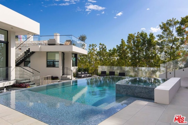 view of pool with an in ground hot tub