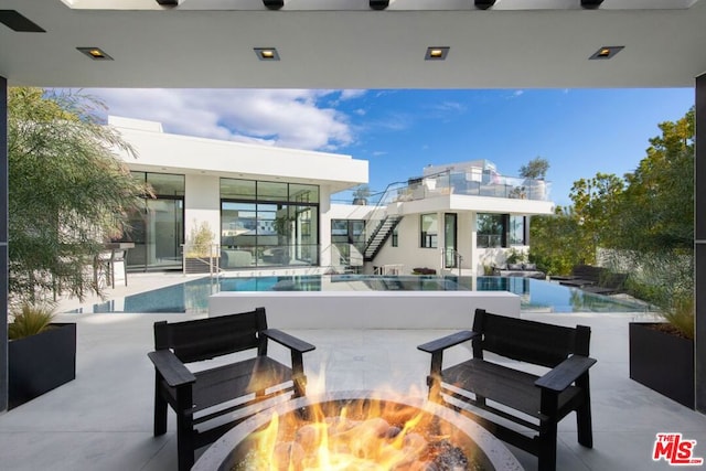 view of patio with ceiling fan and an outdoor fire pit