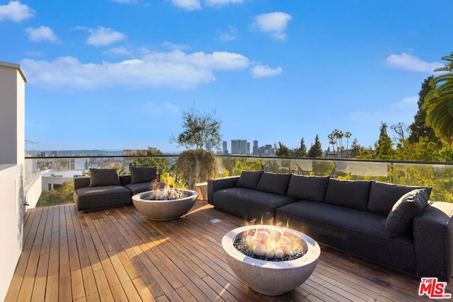 deck featuring an outdoor living space with a fire pit