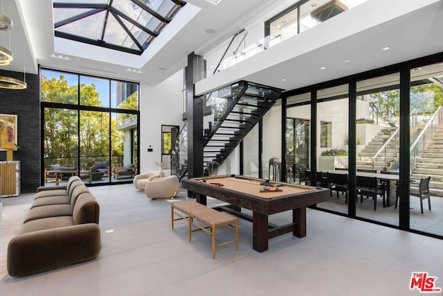 playroom featuring pool table, a wall of windows, and a towering ceiling