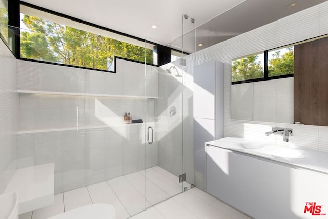 bathroom featuring sink, tile patterned floors, a healthy amount of sunlight, and walk in shower