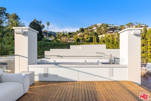 view of swimming pool featuring a wooden deck and sink