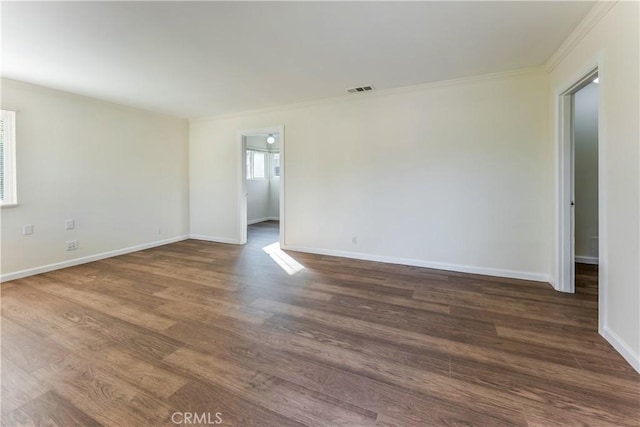 empty room with dark wood-type flooring and crown molding