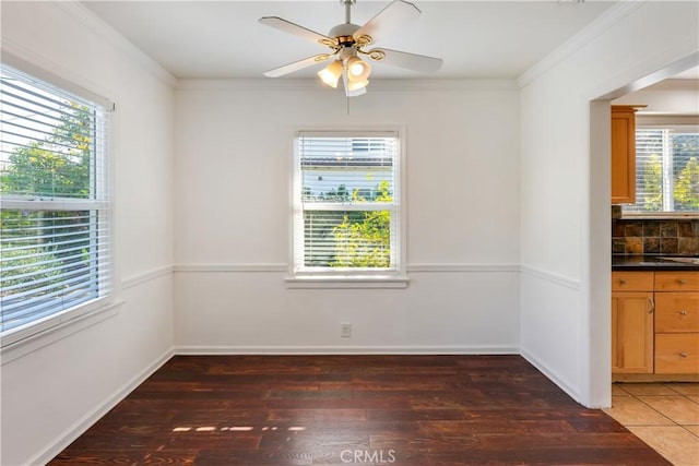 unfurnished dining area with crown molding, ceiling fan, and dark wood-type flooring