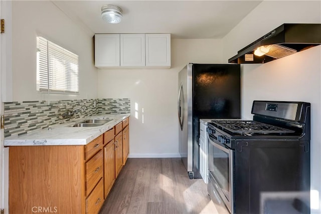 kitchen with range hood, sink, white cabinets, decorative backsplash, and stainless steel appliances