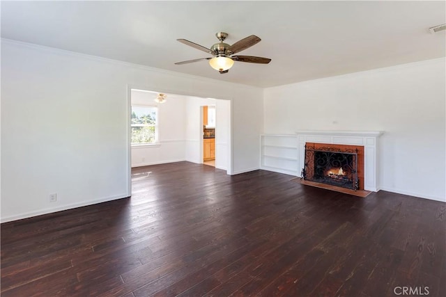 unfurnished living room featuring ceiling fan, dark hardwood / wood-style floors, a fireplace, ornamental molding, and built in shelves