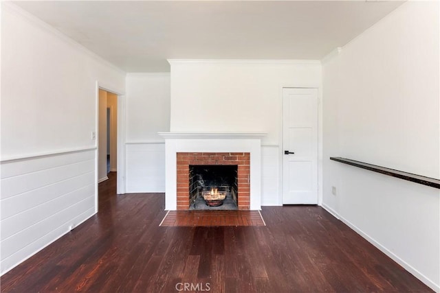 unfurnished living room featuring ornamental molding, dark hardwood / wood-style floors, and a brick fireplace