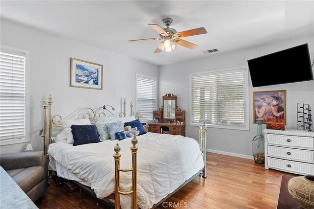 bedroom with multiple windows, ceiling fan, and light hardwood / wood-style flooring