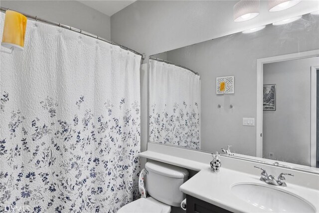 bathroom featuring a shower with curtain, vanity, and toilet