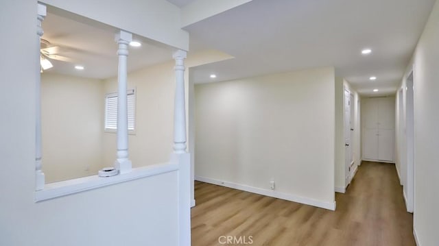 hall featuring decorative columns and light hardwood / wood-style flooring