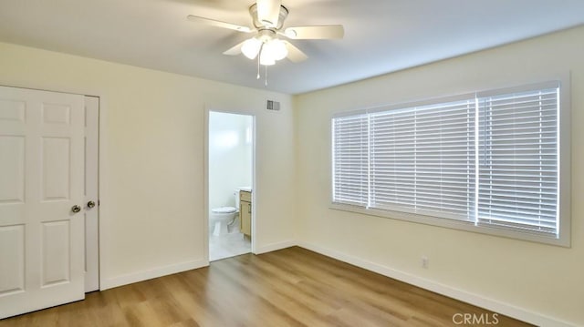 unfurnished bedroom with ceiling fan, ensuite bath, and light hardwood / wood-style flooring