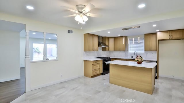 kitchen with wall chimney exhaust hood, sink, hanging light fixtures, black gas stove, and a kitchen island