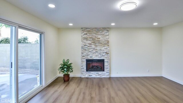 unfurnished living room featuring a large fireplace and light hardwood / wood-style floors