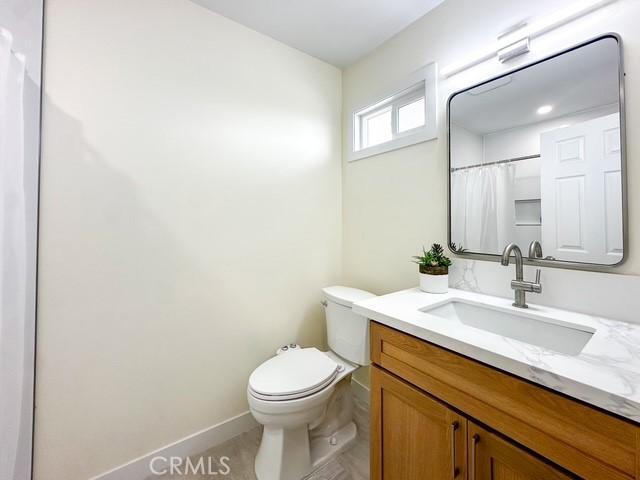 bathroom with a shower with curtain, vanity, and toilet