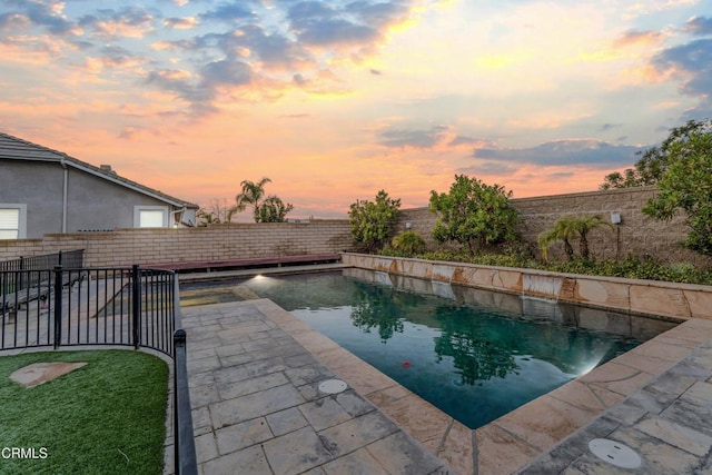 pool at dusk featuring a patio area