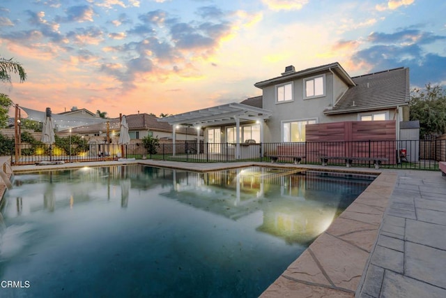 pool at dusk featuring a pergola and a patio area