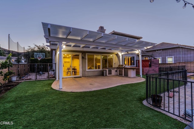 back house at dusk featuring a yard, a pergola, and a patio area