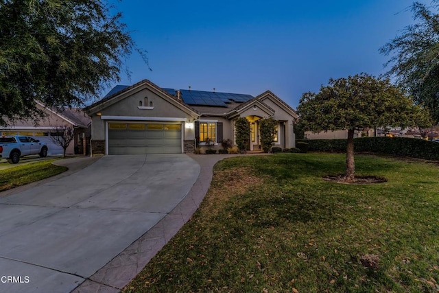 view of front facade with a yard, a garage, and solar panels