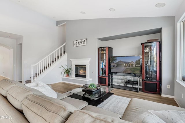 living room featuring high vaulted ceiling and light hardwood / wood-style floors