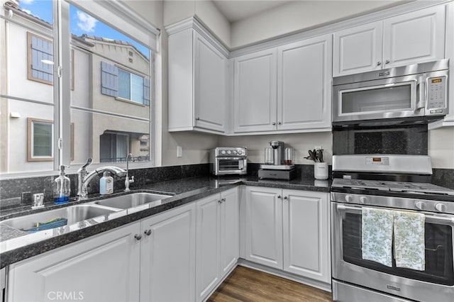 kitchen with white cabinetry, appliances with stainless steel finishes, sink, and dark hardwood / wood-style floors