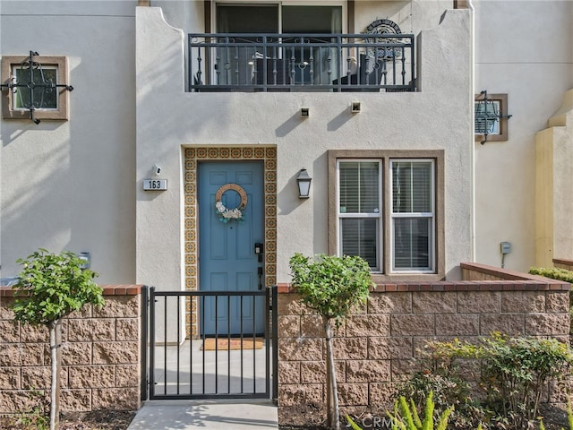 view of exterior entry featuring a balcony