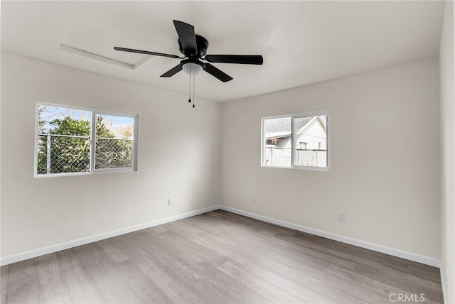 spare room featuring a healthy amount of sunlight, hardwood / wood-style floors, and ceiling fan