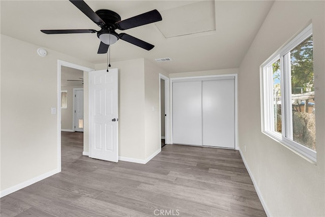 unfurnished bedroom featuring ceiling fan, light hardwood / wood-style floors, and a closet