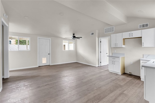 kitchen with white cabinetry, ceiling fan, vaulted ceiling, and light wood-type flooring