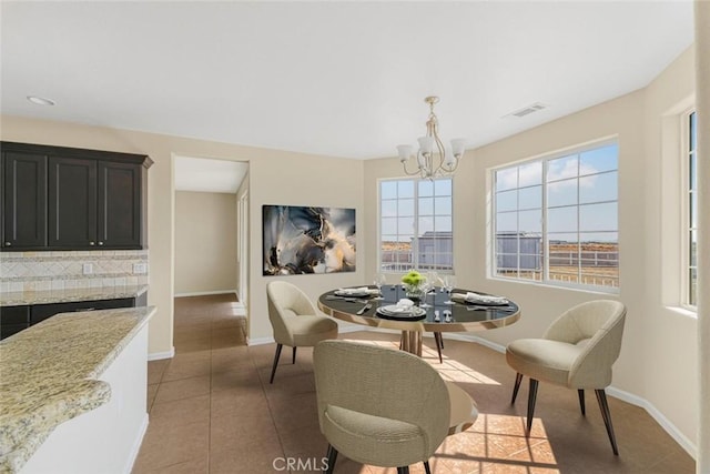 dining area featuring tile patterned flooring and a notable chandelier