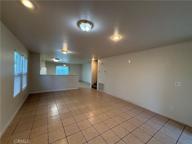 tiled empty room with a textured ceiling