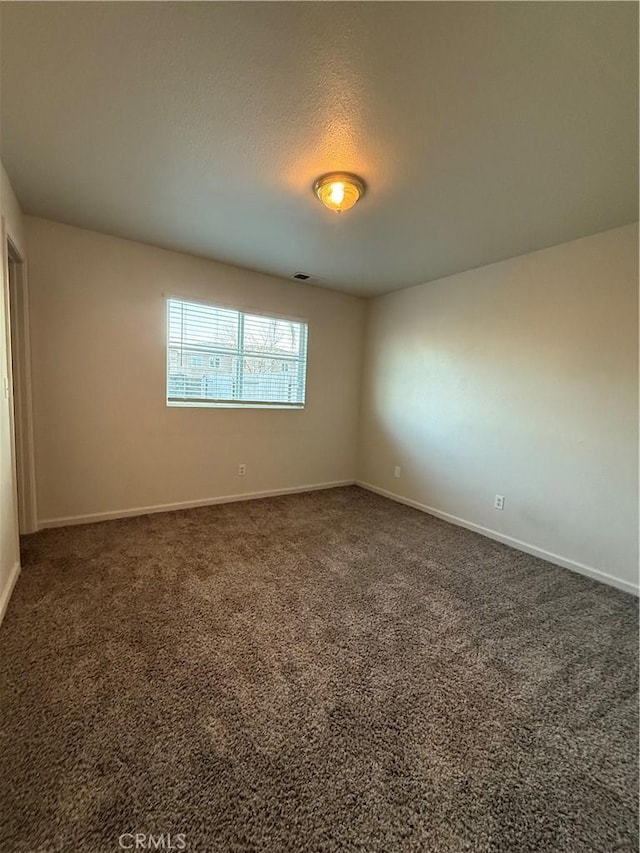 carpeted spare room featuring a textured ceiling