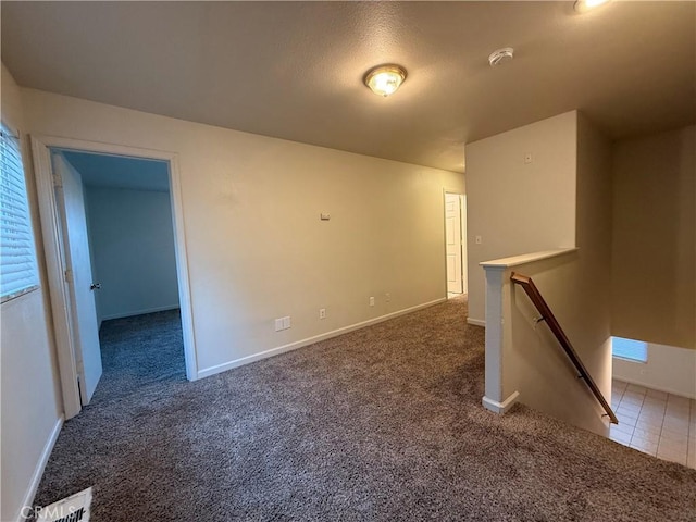 unfurnished room featuring dark colored carpet