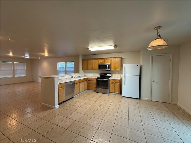 kitchen with hanging light fixtures, light tile patterned floors, stainless steel appliances, and kitchen peninsula