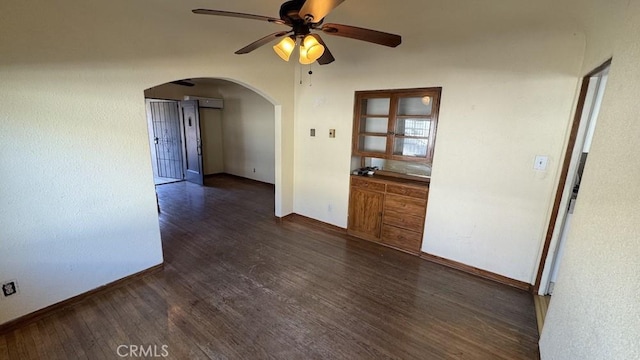 unfurnished room featuring dark wood-type flooring, an AC wall unit, and ceiling fan