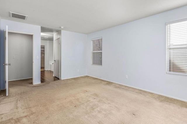 unfurnished bedroom with carpet, visible vents, and baseboards