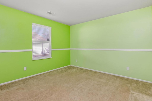 carpeted empty room with visible vents and baseboards