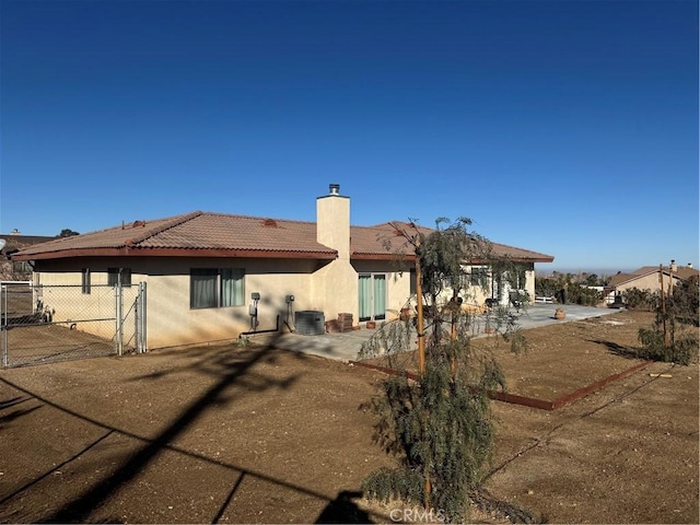 back of house with central AC unit and a patio