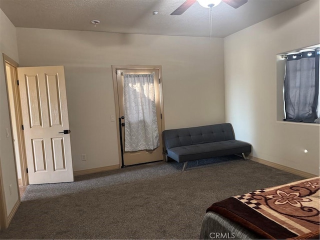 carpeted bedroom featuring ceiling fan and a textured ceiling