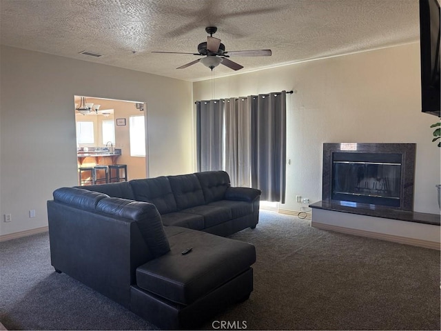 carpeted living room featuring a textured ceiling and ceiling fan