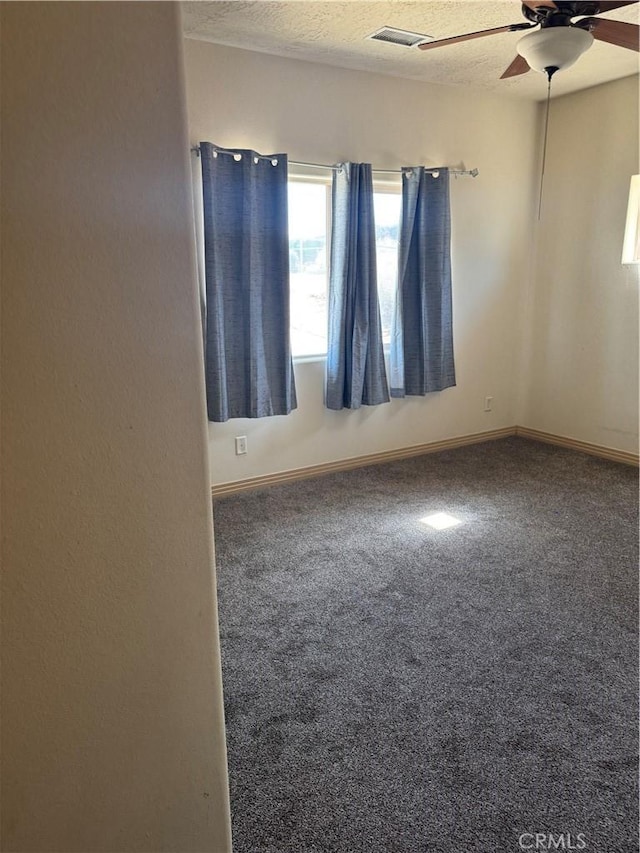 carpeted spare room featuring ceiling fan and a textured ceiling