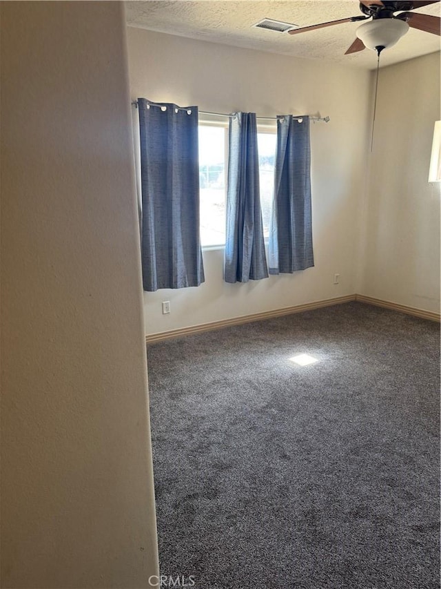 empty room featuring ceiling fan, a textured ceiling, and carpet