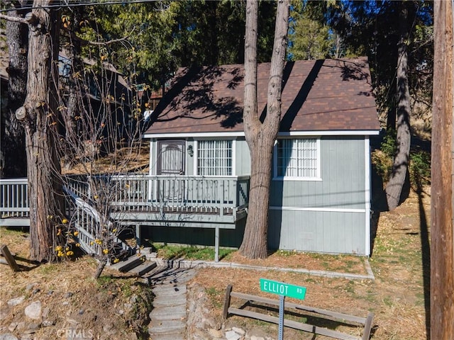 rear view of property featuring a wooden deck